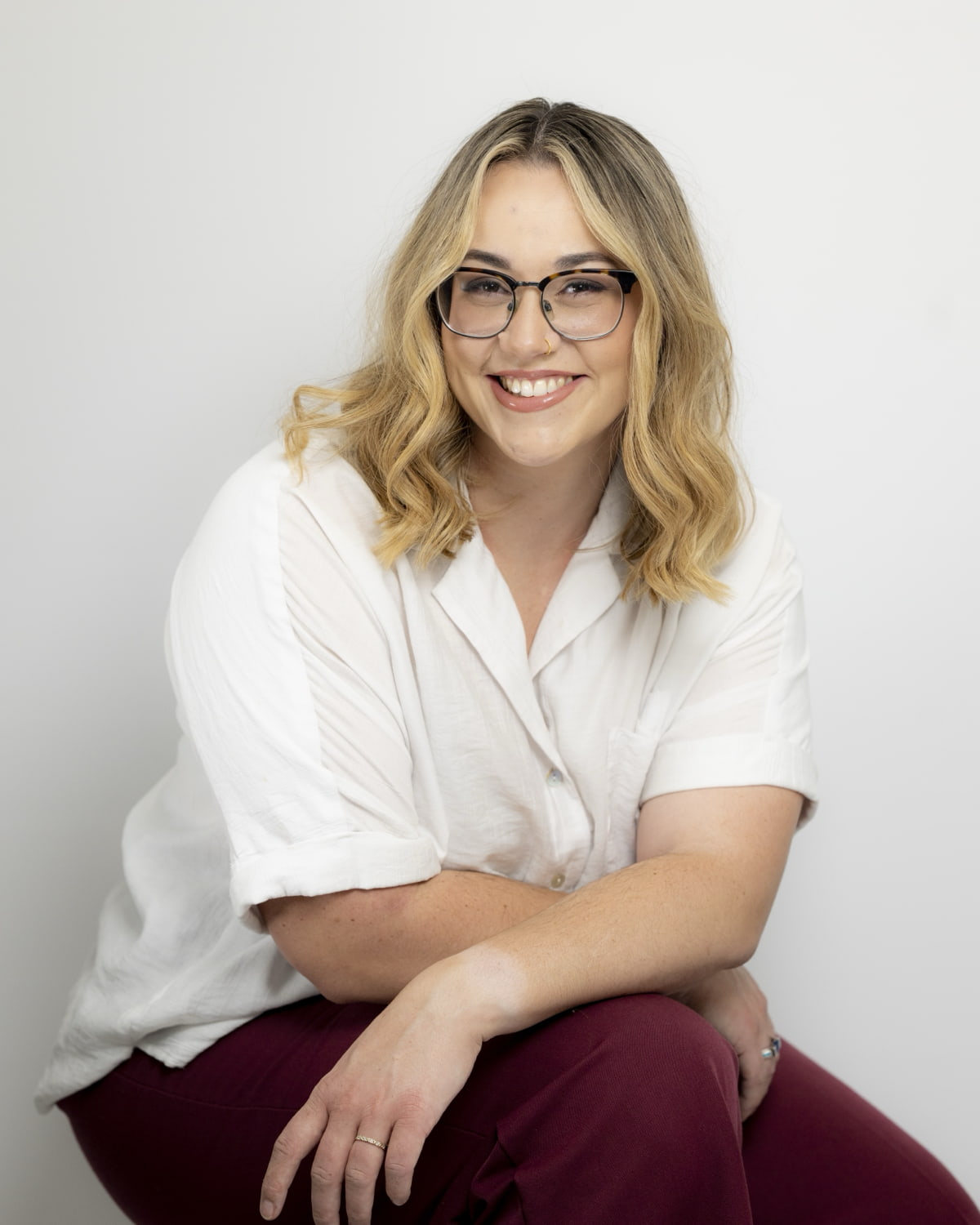 Ashleigh Epton seated in a white shirt, smiling